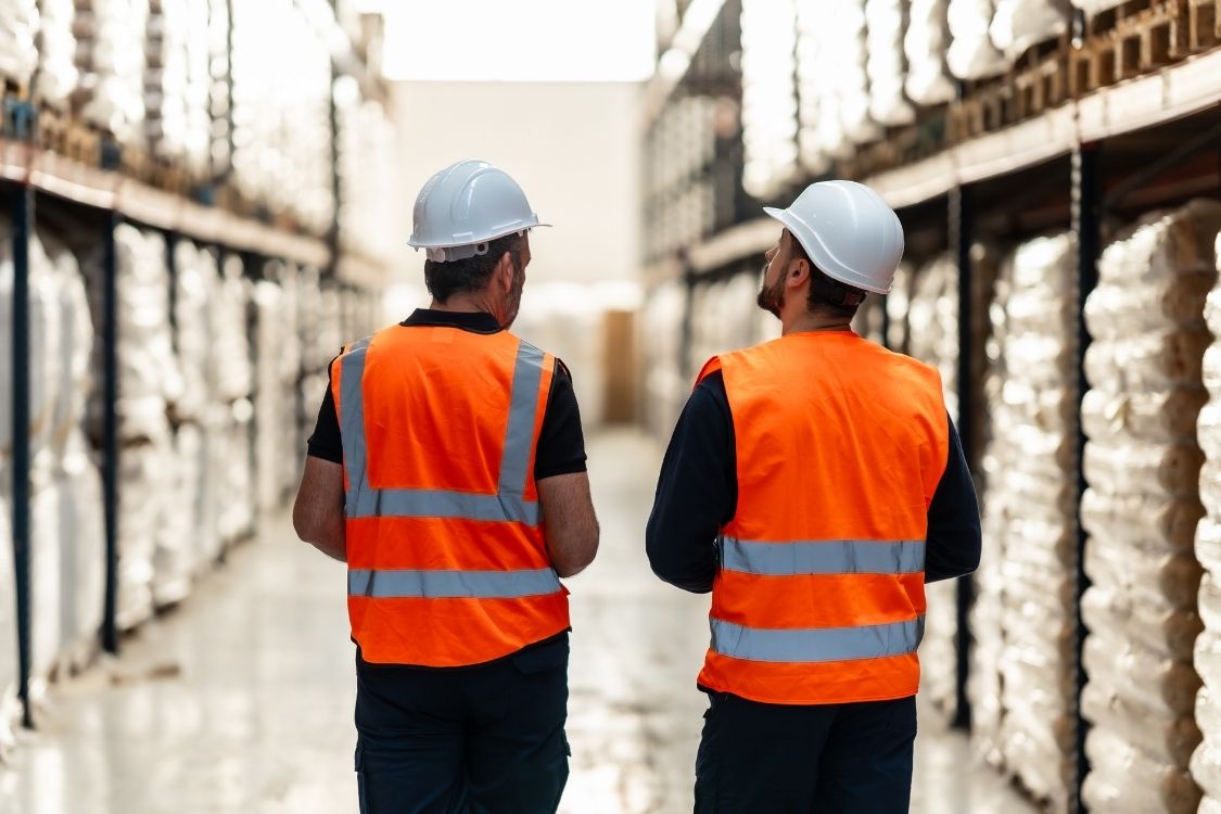 warehousing services with 100 years experience - two warehouse workers examining stock in storage on racking